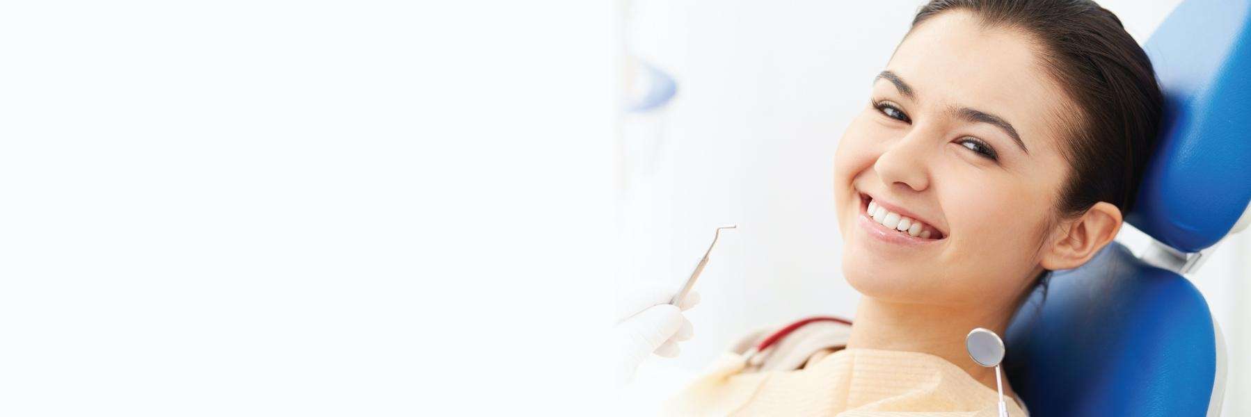 Young woman smiling in dental chair after emergency dental care, foothill ranch ca