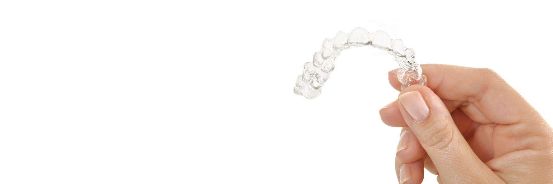 Hand holding tray of Invisalign at dentist in Foothill Ranch