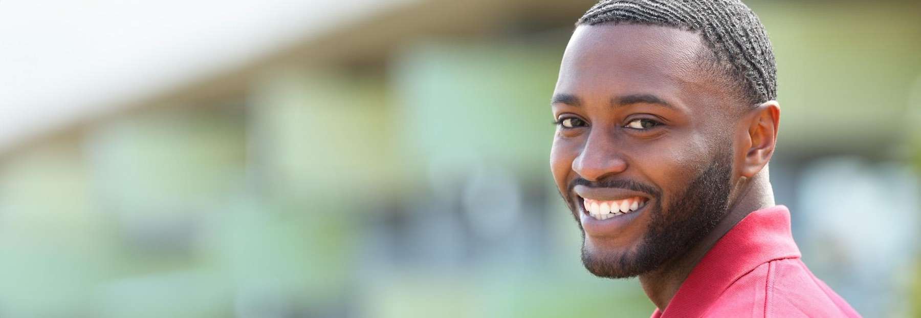 Confident man smiling at the camera, showing bright, whitened teeth