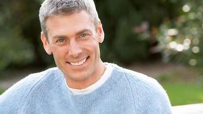White man with grey hair smiling after denture care, foothill ranch ca
