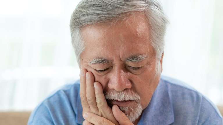 Older asian man holding his mouth in pain, foothill ranch ca