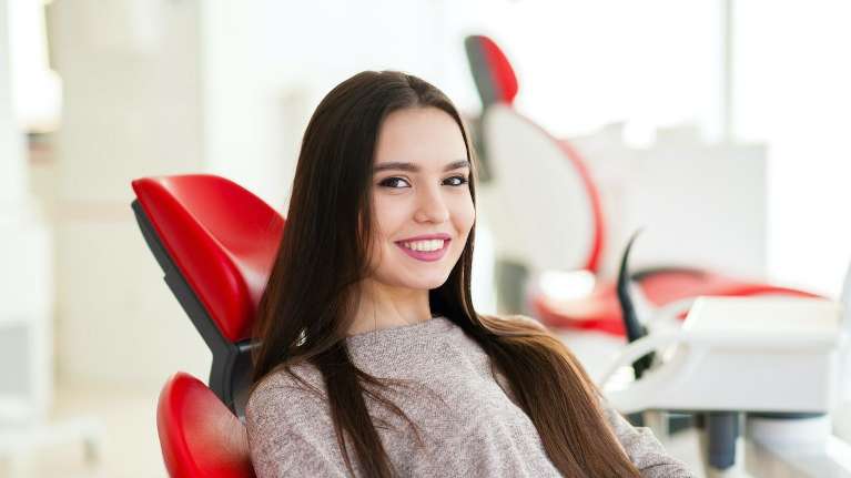 Young woman smiling in dentist chair, foothill ranch ca